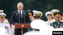 FILE - Russian President Vladimir Putin delivers a speech during the Navy Day parade in St. Petersburg, Russia, July 30, 2017. 