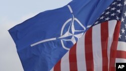 Прапори НАТО і США перед штаб-кватирою НАТО в Брюсселі 