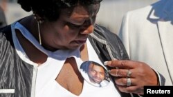 FILE - Valerie Castile, the mother of Philando Castile, looks at a photo button of her son during a press conference on the state capitol grounds in Saint Paul, Minnesota, July 12, 2016.