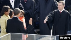 Barack Obama takes the Oath of Office as the 44th President of the United States as he is sworn in by U.S. Chief Justice John Roberts (R) during the inauguration ceremony in Washington, January 20, 2009.