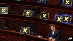 Pro-democracy lawmaker Ronny Tong sits among seats filled with yellow crosses placed after lawmakers walked out of the legislative chamber to protest against Chief Secretary Carrie Lam who presented details of a Beijing-backed election plan, in Hong Kong.