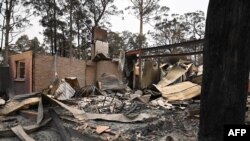 The remains of a house destroyed by a bushfire are seen just outside Batemans Bay in New South Wales, Jan. 2, 2020. Australia authorized forced evacuations amid a mass exodus from fire-ravaged coastal communities.