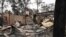 The remains of a house destroyed by a bushfire are seen just outside Batemans Bay in New South Wales, Jan. 2, 2020. Australia authorized forced evacuations amid a mass exodus from fire-ravaged coastal communities.