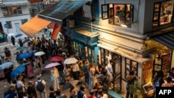人群2024年3月31日聚集在香港上環的一條靜謐小巷，向獨立書店見山書店（Mount Zero Books）告別。 （法新社）