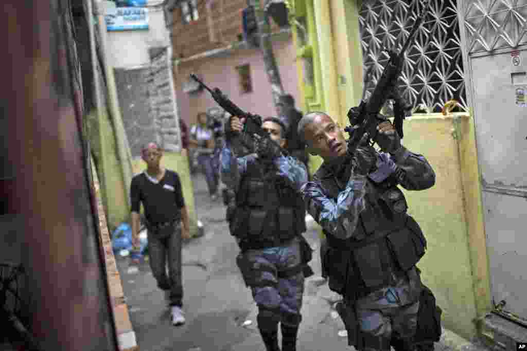 Military police officers patrol in the Roquette Pinto shantytown, part of the Mare slum complex in Rio de Janeiro, Brazil.