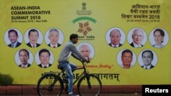 A cyclist rides past an ASEAN-India Commemorative Summit billboard on the side of the road in New Delhi, India, Jan. 23, 2018. 