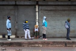 Residents, keeping a distance from one another due to the coronavirus, queue outside a grocery store in the Alexandra township in Johannesburg, South Africa, April 1, 2020.