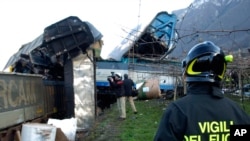 Un pompier regarde deux trains de marchandises entrés en collision dont les conducteur ont été tués près de la gare Borghetto sull'Adige dans le nord de l'Italie, 13 décembre 2006. (AP Photo / Daniele Mosna)