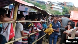 Seorang anak laki-laki pengungsi Rohingya mengambil daging di pusat pembagian bantuan di kamp pengungsi Balukhali di Cox’s Bazar, Bangladesh, 23 Agustus 2018.