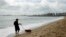 A man walks his dog on the beach during the 2014 soccer World Cup in Fotaleza, Brazil, June 17, 2014.  