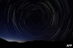 A multiple exposure picture taken August 2013 shows a meteor shower in the sky on the mountains of the Sierra Norte de Madrid. (AFP PHOTO / DANI POZO)