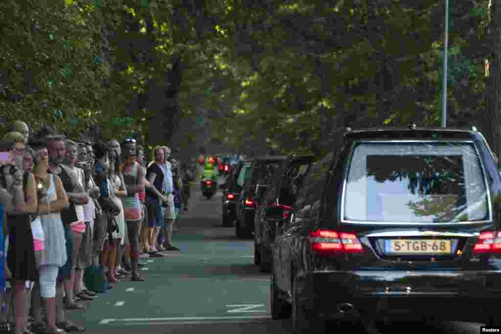 People pay their respects as a convoy of hearses, bearing remains of the victims of the Malaysia Airlines Flight MH17 crash, drive past in Hilversum, Netherlands, July 23, 2014. 