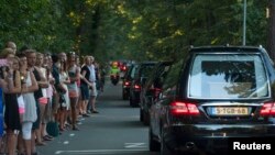 People pay their respects as a convoy of hearses, bearing remains of the victims of the Malaysia Airlines Flight MH17 crash, drive past in Hilversum, Netherlands, July 23, 2014. 