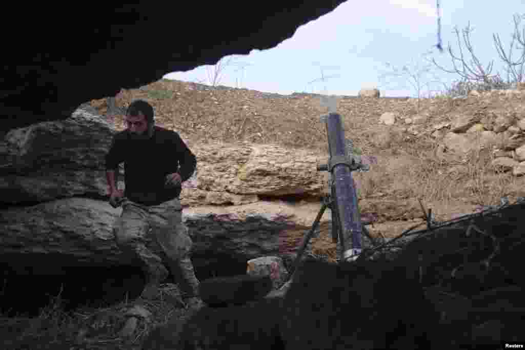 A Free Syrian Army fighter runs after launching a mortar towards forces loyal to Syria's President Bashar al-Assad that are camped in the Valley of Al-Dayf and Al-hamdeh, in Idlib, Jan. 11, 2014. 