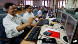 Indian stockbrokers celebrate as they watch the Bombay Stock Exchange (BSE) index on their trading terminal in Mumbai, India, May 13, 2014.