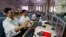 FILE - Indian stockbrokers celebrate as they watch the Bombay Stock Exchange (BSE) index on their trading terminal in Mumbai, India.