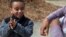 FILE - Nathan Aragaw, 4, mimics his mother, Mule Haile, of Washington, DC, as she instructs him on how to apply hand sanitizer between his fingers and on the backs of his hands after playing soccer at a public park, March 16, 2020.