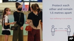 Para pengunjung diwajibkan mengenakan masker saat berjalan-jalan di pusat perbelanjaan di Sydney, Australia, Minggu, 3 Januari 2021. (AP Photo/Mark Baker)