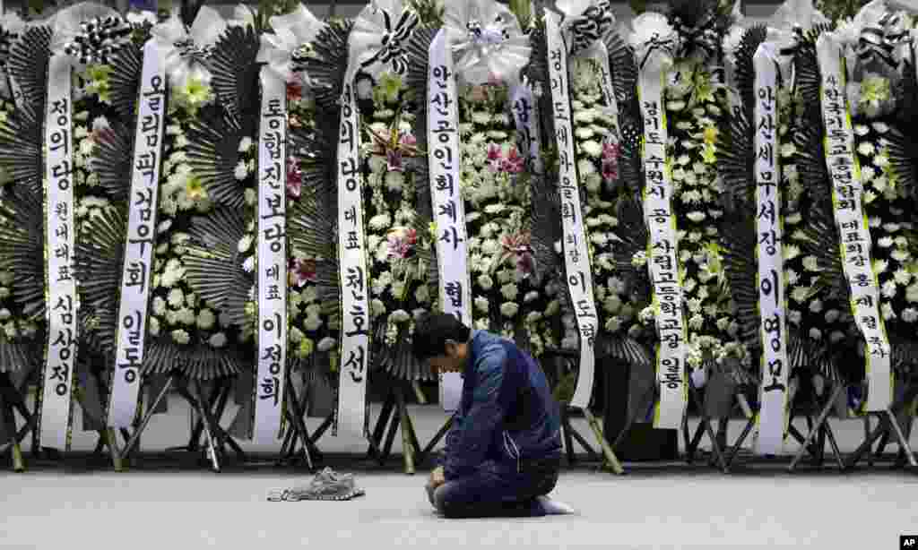 A mourner pays tribute to the victims of the sunken ferry Sewol near condolence flowers at a temporary memorial at the auditorium of the Olympic Memorial Museum in Ansan, South Korea, April 24, 2014.