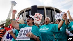 FILE - Lydia Balderas, left, and Merced Leyua, right, join others as they protest against a new sanctuary cities bill outside the federal courthouse in San Antonio, June 26, 2017. A federal judge late Wednesday temporarily blocked most of Texas’ tough new “sanctuary cities” law.