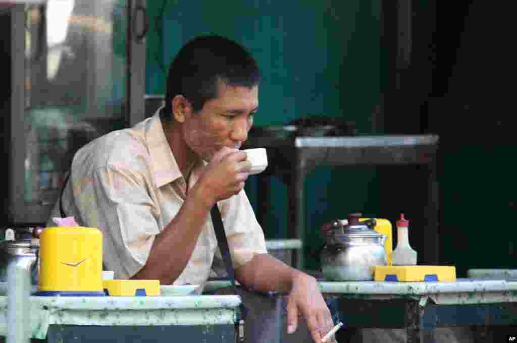 A man relaxes in a Rangoon tea shop. (VOA-D.Schearf)