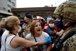 An anti-government protester scuffles with Lebanese army soldiers in the town of Zouk Mosbeh, north of Beirut, Lebanon, April 27, 2020.