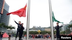 澳门警察在金莲花广场升起中国国旗和澳门特区旗帜。（2019年12月19日）