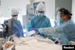 Dr. Dan Ponticiello (43), dan Dr. Gabriel Gomez (40), mengintubasi pasien COVID-19 di ruang ICU COVID-19 Rumah Sakit Misi Providence di Mission Viejo, California, AS, 8 Januari 2021. (REUTERS)