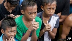 Boys watch the round-by-round live satellite broadcast from Las Vegas of the welterweight boxing title fight between the Philippines' Manny Pacquiao and American Floyd Mayweather Jr., at suburban Marikina city, east of Manila, Philippines, May 3, 2015. 