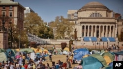 ARCHIVO - Estudiantes escuchan a un orador en un campamento pro palestino que pide un alto el fuego permanente en Gaza, dentro del campus de la Universidad de Columbia, el domingo 28 de abril de 2024, en Nueva York.