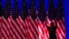 Un trabajador ajusta las banderas en el escenario antes de un evento en el comando de campaña del candidato presidencial republicano Donald Trump, en West Palm Beach, Florida, el 5 de noviembre de 2024.