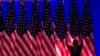 A worker adjusts the flags on stage ahead of an election night watch party for Republican presidential nominee former President Donald Trump in West Palm Beach, Fla., Nov. 5, 2024.