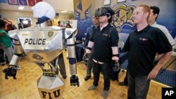 FILE - Students control a "Robocop" during a demonstration at Florida International University, Feb. 12, 2014, in Miami.