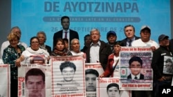 President-elect Andres Manuel Lopez Obrador, center, poses with the relatives of some the 43 college students who disappeared on Sept. 26, 2014, at the Memory and Tolerance Museum in Mexico City, Sept. 26, 2018. 