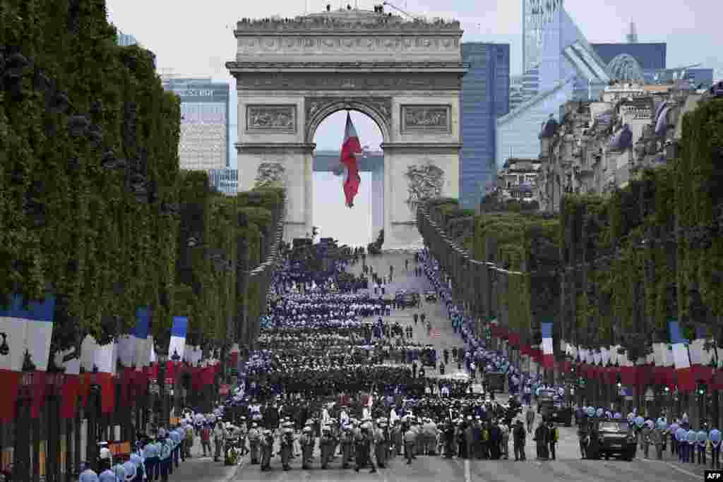 Troops wait near the Arc de Triomphe, in Paris, France, before taking part in the annual Bastille Day military parade on the Champs-Elysees avenue.