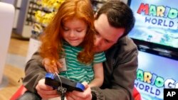 FILE - A child is seen playing a game at Nintendo World in New York.