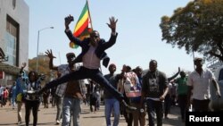 Supporters of the opposition Movement for Democratic Change (MDC) party of Nelson Chamisa, sing and dance as they march in the streets of Harare, Zimbabwe, August 1, 2018. REUTERS/Siphiwe Sibeko TPX IMAGES OF THE DAY - RC1D753F93A0
