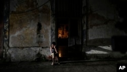 A resident sits while passing time during a blackout following the failure of a major power plant in Havana, Cuba, Oct. 19, 2024. 