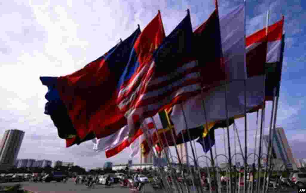 Motorcyclists ride past the flags of participating countries of the ministerial meeting of the Association of Southeast Asian Nations (ASEAN) in Hanoi on July 19, 2009.