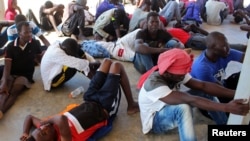 FILE - Migrants are seen after being rescued by Libyan coast guard in Khoms, Libya, Aug. 27, 2019.