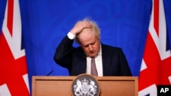 Britain's Prime Minister Boris Johnson gestures as he speaks during a press conference in London, Nov. 27, 2021, after cases of the new COVID-19 variant were confirmed in the UK.