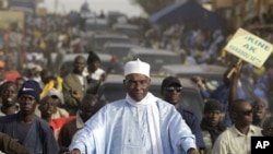 Senegalese President Abdoulaye Wade is surrounded by supporters and security as he travels between campaign stops in downtrodden suburban neighborhoods of Dakar, Senegal Wednesday, Feb. 22, 2012. 