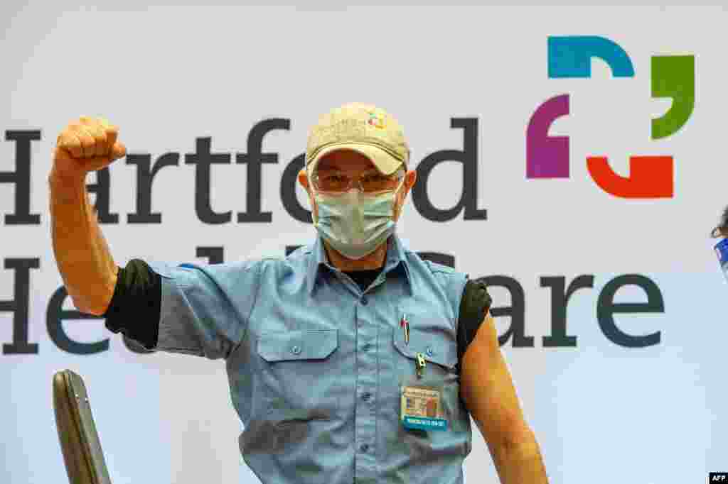 Orgulloso, el trabajador de asistencia a la Salud, Wilfredo Rivera, celebra haber recibido la vacuna Moderna contra el nuevo coronavirus en el Hospital Hartford, estado de Connecticut, el 21 de diciembre de 2020. [AFP]