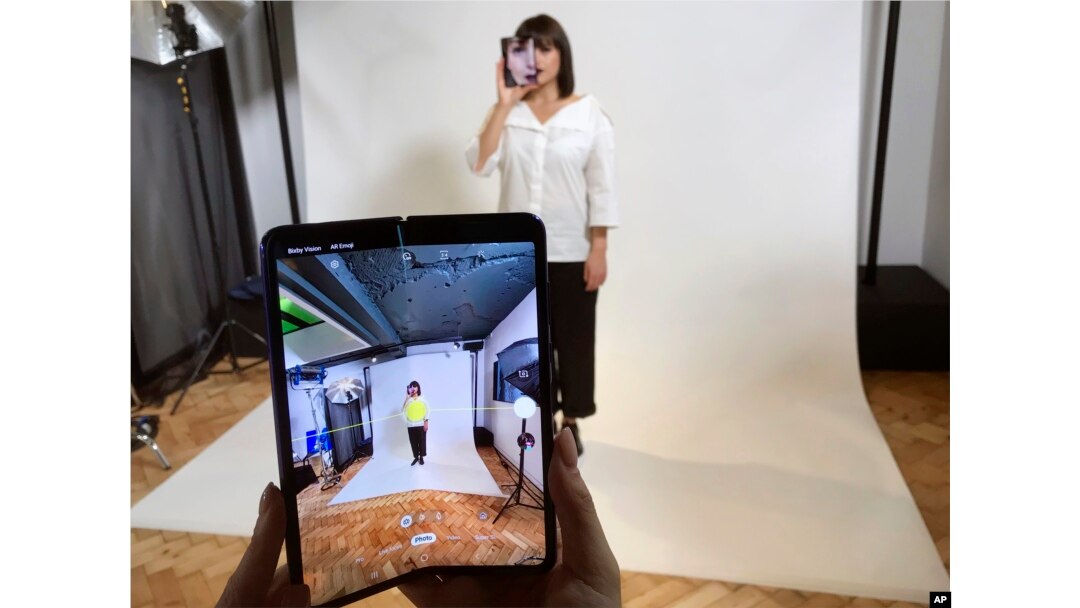 Seorang model memegang ponsel pintar Samsung Galaxy Fold ke arah wajahnya dalam acara untuk media di London, 16 April 2019.
