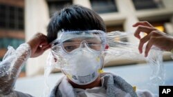 A Hong Kong pro-democracy protester covers his face in plastic wrap to protect against pepper spray in the event that it is used by the police, Sept. 29, 2014.