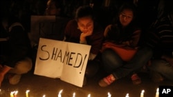 Warga menyalakan lilin tanda duka cita atas kematian korban pemerkosaan beramai-ramai di New Delhi (29/12). (AP/Saurabh Das)
