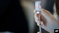 ARHIVA - Lekar priprema dozu Modernine vakcine protiv kovida 19 u Los Anđelesu, 29. marta 2021. (Foto: AP/Gerald Herbert)