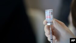 FILE - A worker readies syringes with the Moderna COVID-19 vaccine in Metairie, Louisiana, March 29, 2021.