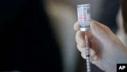 FILE - A worker readies syringes with the Moderna COVID-19 vaccine in Metairie, Los Angeles, March 29, 2021.