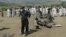 A security official and residents inspect the site of a bomb attack in the Lower Dir tribal area in Pakistan September 16, 2012. 